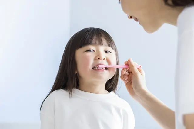 こどもに正しい歯磨きを教えている様子